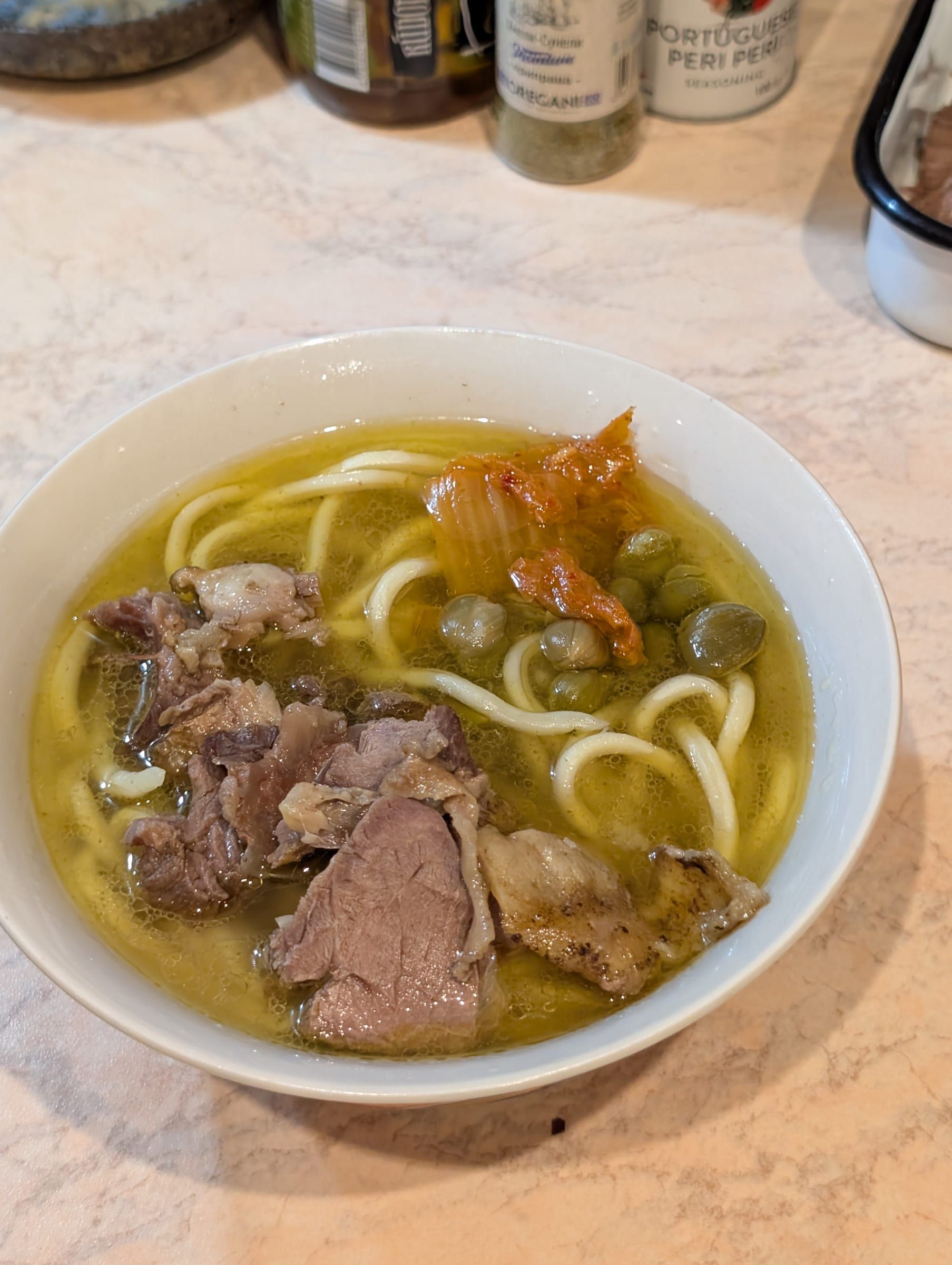 Миска лапши в прозрачном бульоне с отварным мясом и кимчи